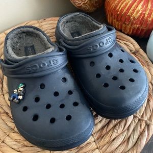 Size 1 blue crocs with grey fur and one jibbitz.